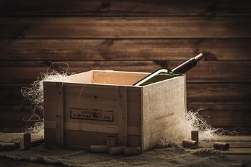 Bottle of wine in box in wooden interior - 64787326