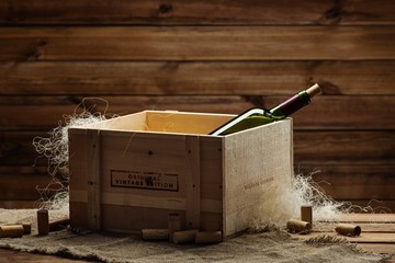 Bottle of wine in box in wooden interior