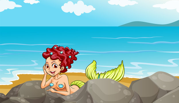 A mermaid at the seashore near the rocks