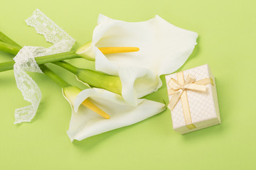 gift and white lilly flowers on green