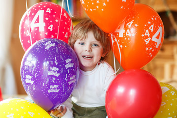 Fototapeta na wymiar Happy little boy celebrating his 4 birthday with colorful balloo