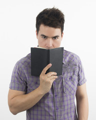 Man Think and hides his face behind a book.