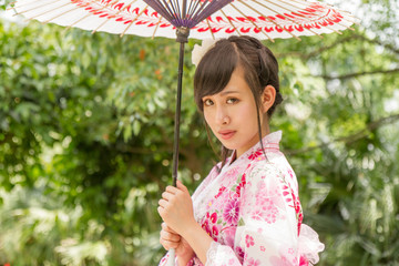 Asian woman wearing a yukata and holding an umbrella