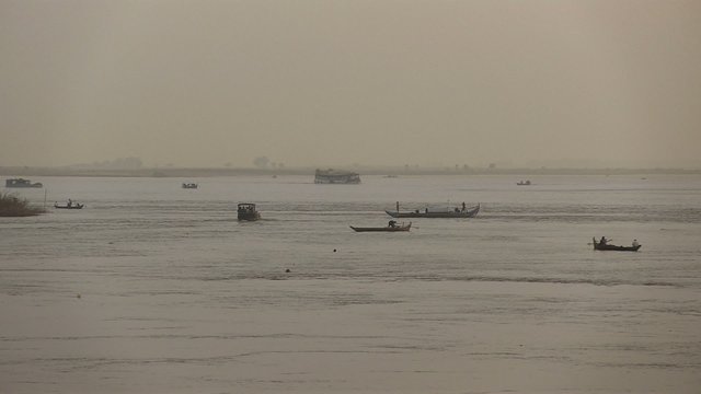 River traffic with various boat types on the Mekong River with early morning fog