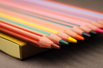Naklejka premium Coloring pencils in a row on a notebook