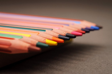 Pointed colorful pencils in a row