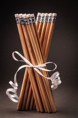 Two bunches of pencils with a white ribbon