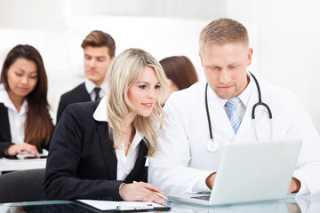 Fototapeta premium Male Doctor And Businesswoman With Laptop