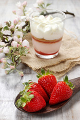 Strawberries on wooden spoon and glass of strawberry layer puddi