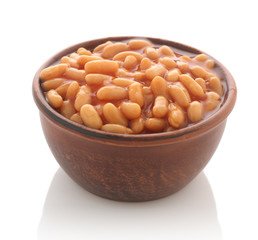 Cooked beans with red sauce in a clay bowl