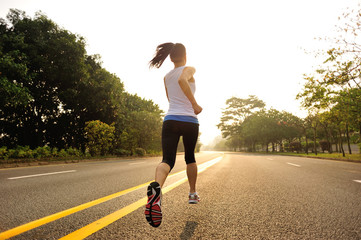 Runner athlete running on sunrise road