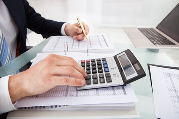 Businessman Holding Calculating Expense In Office