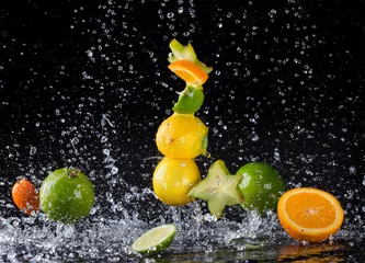 Zitrusfrüchte im Spritzwasser auf schwarzem Hintergrund © Jag_cz