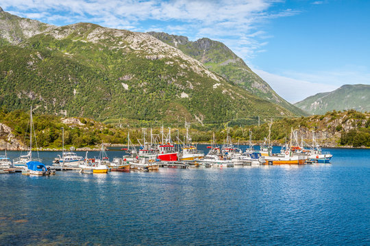 Red and white fishing boats stand moored in Norway village