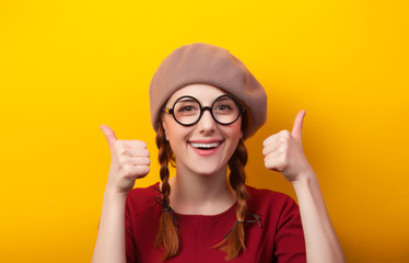 Redhead girl with pigtails on yellow background.