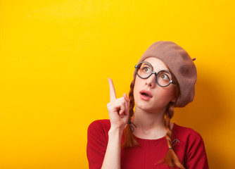 Obraz premium Redhead girl with pigtails on yellow background.