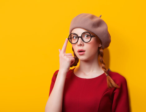 Redhead girl with pigtails on yellow background.