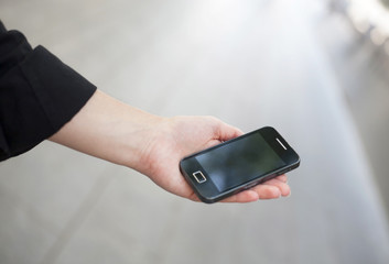 Hand of a businessman holding a mobile. Isolated on white.