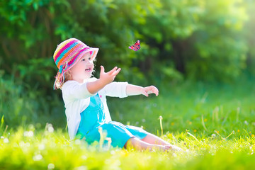 Happy toddler girl playing with butterfly
