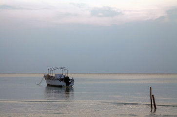 Grey skies dawn seascape single boat