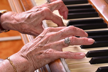 Old woman playing the piano closeup