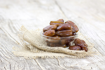 dried dates in a bowl on wooden background