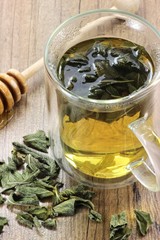 Salbeitee im Glas auf Holztisch