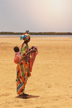 femme africaine portant b&eacute;b&eacute; das le dos