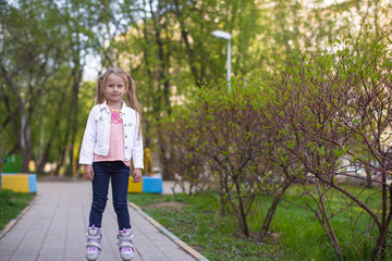 Adorable little girl on roller skates in the park