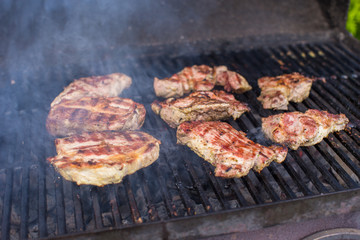 T-bone steak cooking on an open flame grill