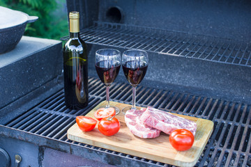 Fresh meat, vegetables and bottle of wine on a picnic outdoors