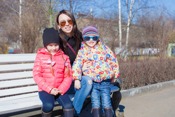 Portrait of two little girls and young mother have fun outdoors