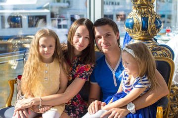 Portrait charming beautiful family of four in restaraunt