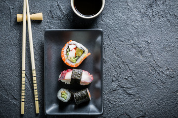 Obraz na płótnie Canvas Sushi served on a black ceramic with soy sauce
