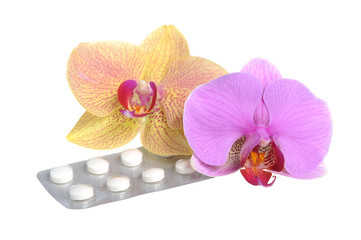 Two orchid flowers with film-coated tablets isolated