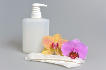 Obraz na płótnie Canvas Intimate gel dispenser pump plastic bottle, sanitary towel, orch