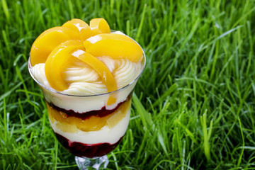 Layer peach and strawberry dessert with whipped cream topping