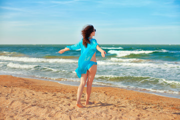 Young happy woman on the beach enjoying vocation