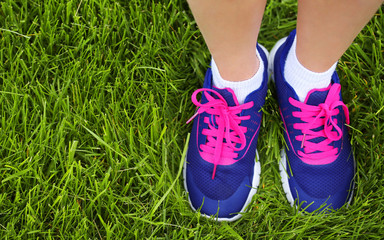Sport Footwear on Female Feet on Green Grass. Closeup Running