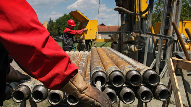 Drilling Rig And Two Oil Workers