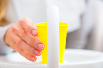 Patientin mit Becher Mundwasser beim Zahnarzt 