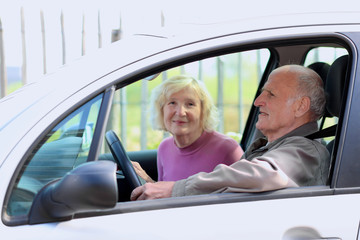 Active senior couple driving the car