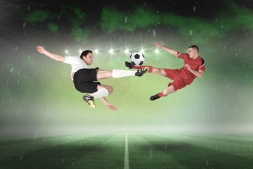Obraz na płótnie Canvas Football players tackling for the ball