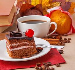 Chocolate cake and cup of coffee with books and autumn leaves