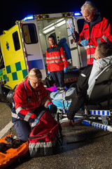 Paramedic team assisting injured motorbike driver