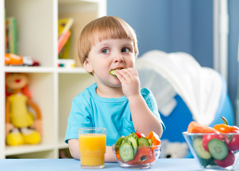 kid boy eating vegetables at home interior © Oksana Kuzmina
