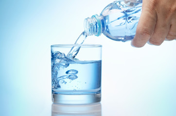 pure water is emptied into a glass of water from bottle