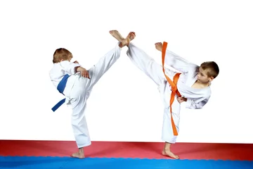 High kicks legs athletes are training on the red and blue mat