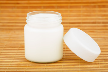 the jar with home yoghurt on a straw mat