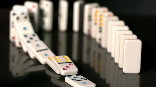 Finger pushing over colourful dominoes